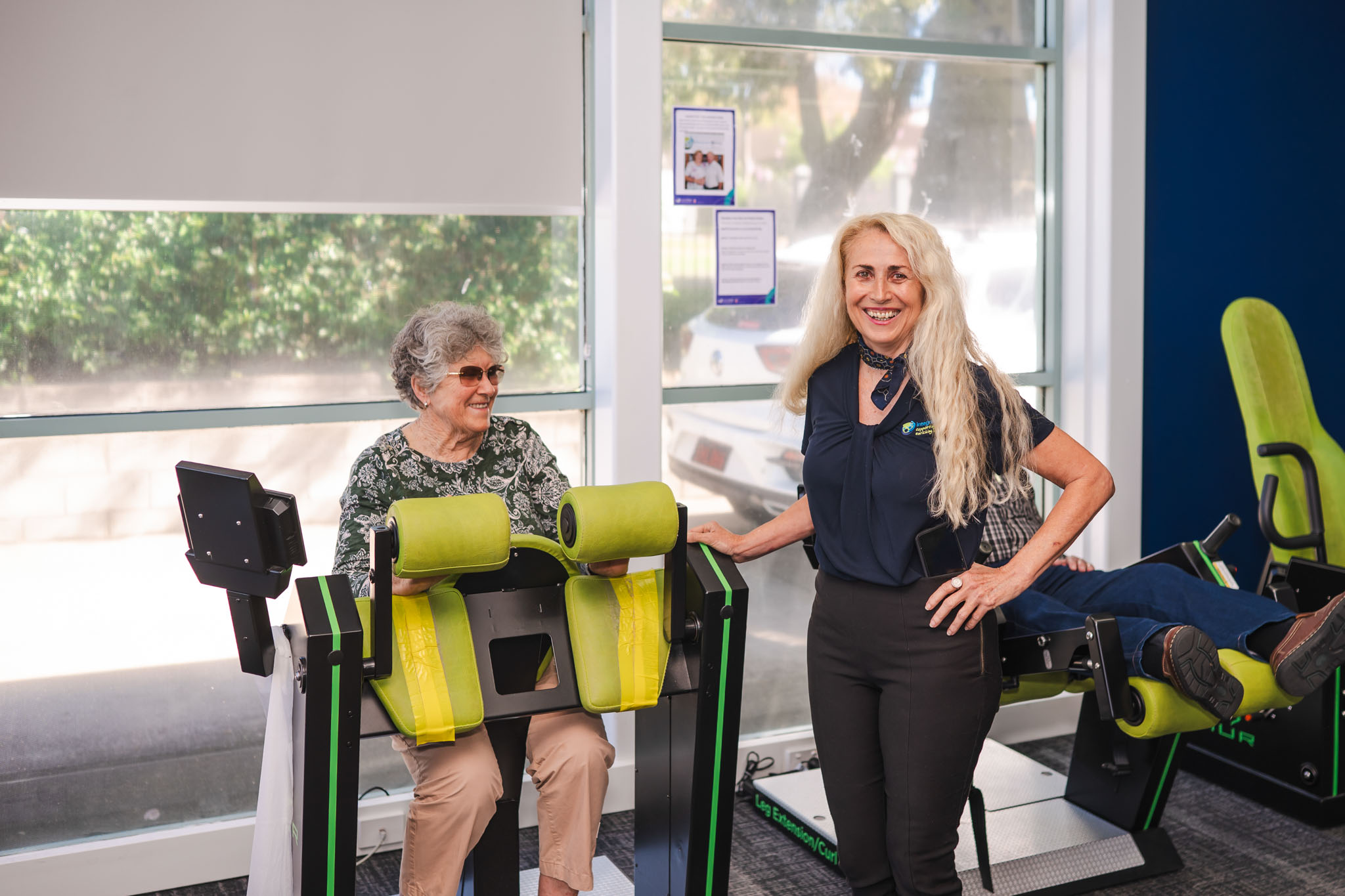 Toowoomba Wellness Centre team member with a smiling client on HUR exercise machine